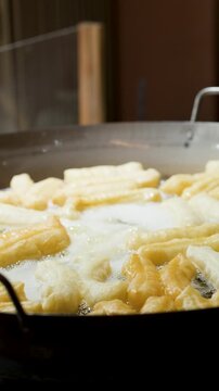 Deep Frying Traditional Chinese Dough Sticks in a Large Hot Wok