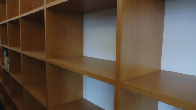 Medium side shot of an office administrator removing folders from open filing shelves. Ideal for workplace organization, records management, business administration, and archive concepts.