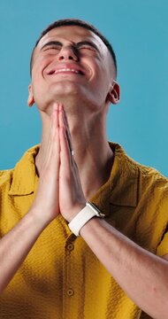 Hope, prayer and religion with man pleading in studio for begging, confession or wish. Asking, luck and praying with desperate person on blue background for belief, christianity or faith in God