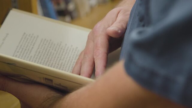 white man reading a book in prison in law library