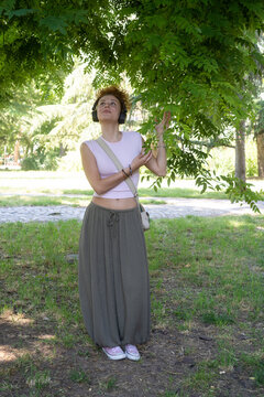 Young woman listening to music on headphones in the park