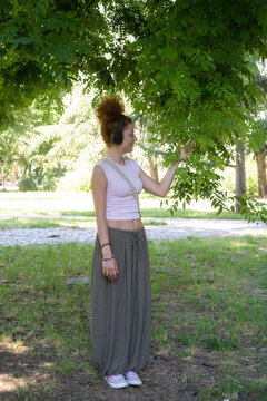 Young woman listening to music on headphones in the park