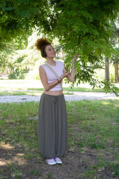 Young woman listening to music on headphones in the park