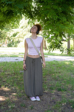 Young woman listening to music on headphones in the park