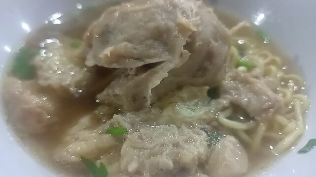 Macro shot of Indonesian beef meatball soup Bakso with rich savory broth