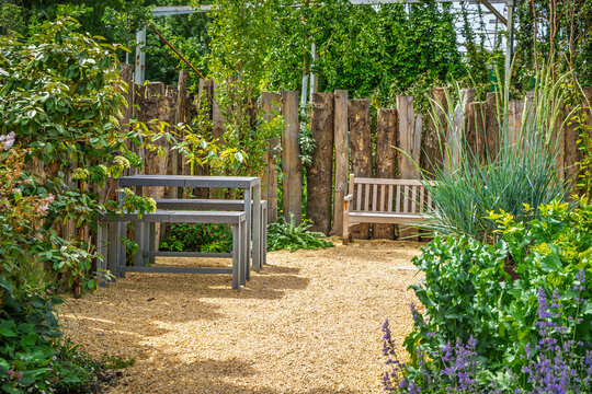 Modern outdoor seating area with gravel and rustic log fence