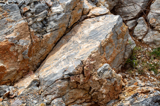Massive Solid Rock Formation with Earthy Brown Soil and Grey Slate Textures