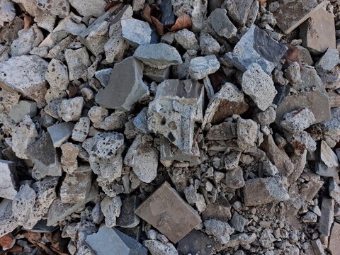 Close-up of demolished building materials showing broken concrete, bricks, and debris with rough textures. Ideal for construction, renovation, recycling, and industrial themes.