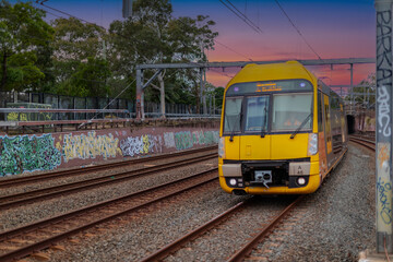 Fototapeta premium 7 July 2026 Passenger Train going through Lewisham Train Station at Sunset a suburban Sydney train Station in Sydney NSW Australia