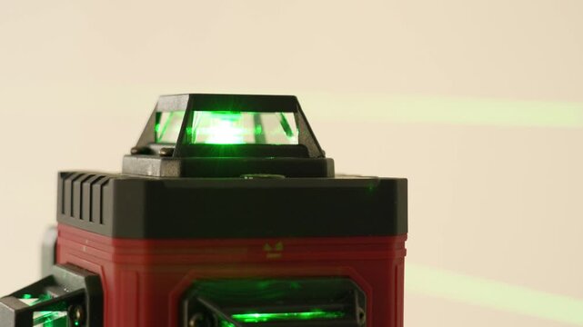 Red and black device features a green laser light. Green beams shine straight in the scene. This is ideal for presentations or measurements. Smooth surfaces show precise design