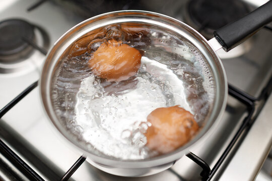 Saucepan stainless steel with boiling eggs for breakfast in a water on a gas stove