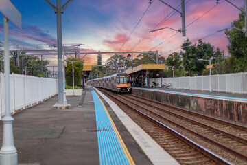 Obraz premium 7 July 2026 Passenger Train going through Lewisham Train Station at Sunset a suburban Sydney train Station in Sydney NSW Australia
