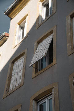 Mediterranean house facade with outward-opening shutters.