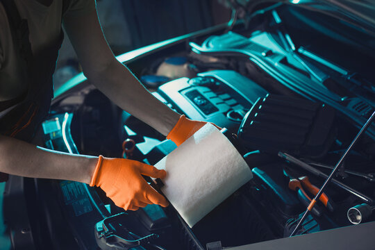 auto mechanic is changing the air filter in the car
