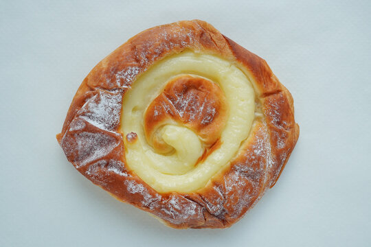 Overhead shot of delicious traditional Spanish ensaimada bun with custard filling