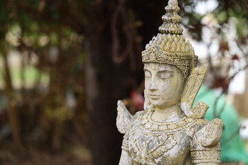 Obraz premium Ancient Stone Angel Statue in Traditional Thai Garden Setting