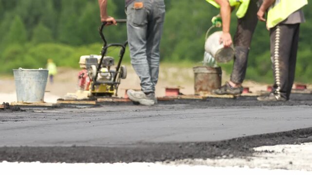 Moscow, May 20 2026, Workers use a vibrating platform to lay asphalt pavement in places that are difficult to reach for heavy equipment. Laying asphalt thrombo vko asphalt new asphalt. Construction