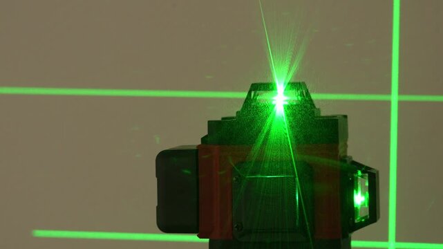 Green laser beam shines from a device. Crosshairs form on the background. The light is vivid and precise. Ideal for science or tech projects