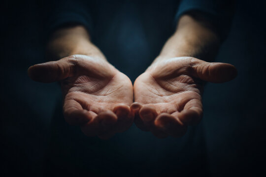 AI generated open hands extended forward gentle offering gesture dramatic lighting symbolizing hope kindness support compassion trust generosity human connection dark background