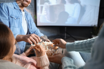 Obraz premium Family eating popcorn while watching movie at home