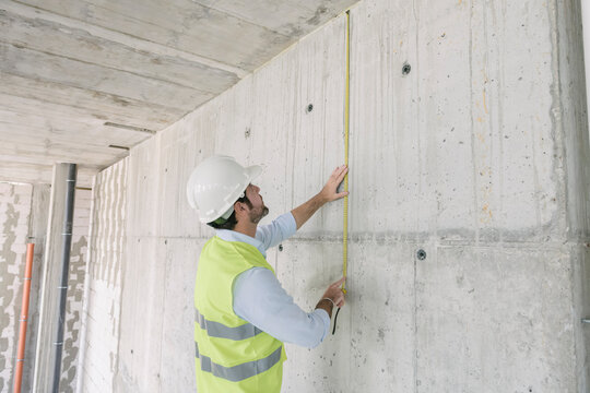 Architect metering a wall at construction site
