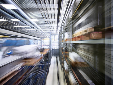Narrow alley amidst blurred motion of racks