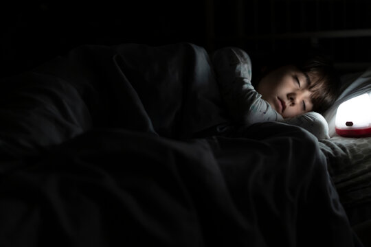 Girl sleeping in bed at night with night light
