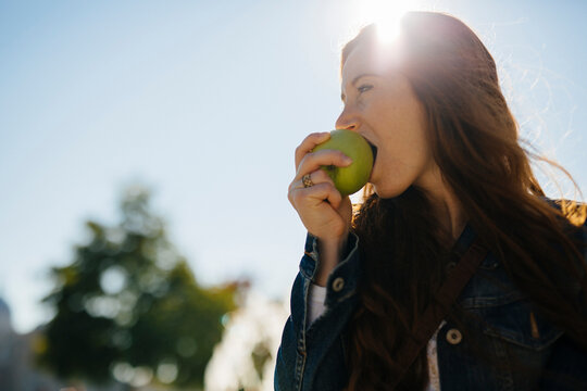 Woman biting into an apple