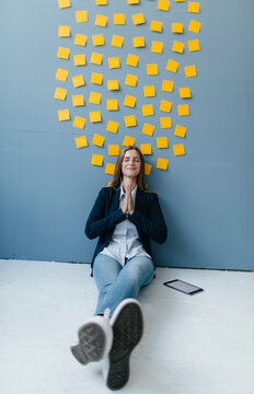 Young businesswoman sitting under data cloud, meditating