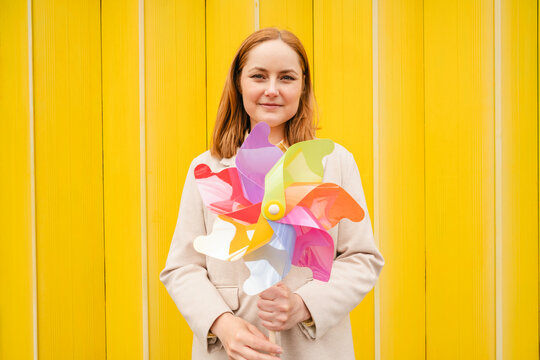 Smiling businesswoman holding colorful pinwheel for innovation