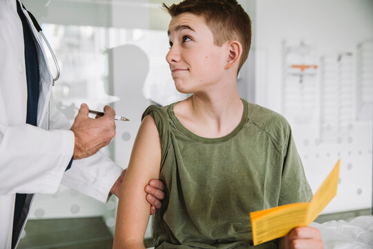 Doctor injecting a vaccine into teenager?s arm