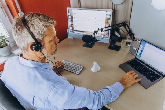 Businessman hosts a remote podcast at the office desk