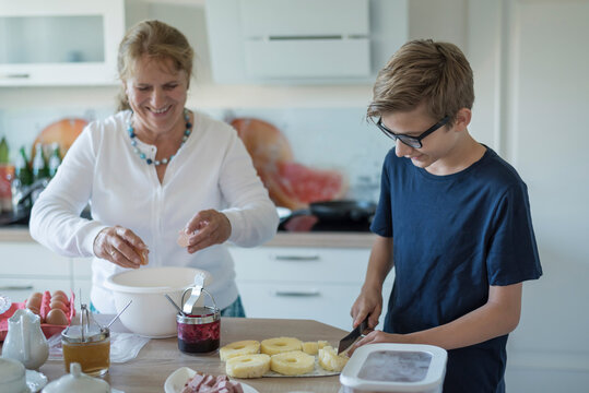 Grandson helping grandmother in kitchen