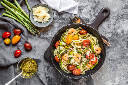 spaghetti with shrimps, green asparagus, tomato, pesto and parmesan