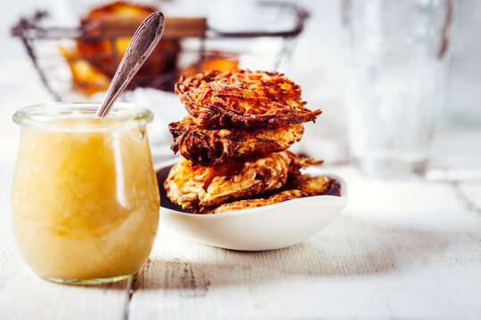 Jar of apple sauce and bowl of crunchy Jewish latkes