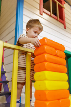 Focused toddler child playing with big toy bricks at kids club