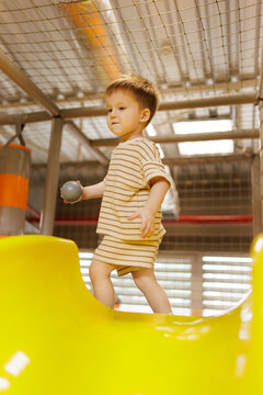 Toddler child playing on indoor playground at amusement center