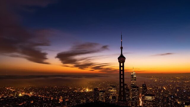City skyline at dusk with illuminated buildings and a prominent tower, showcasing the vibrant lights and colors of an urban landscape in the evening sky