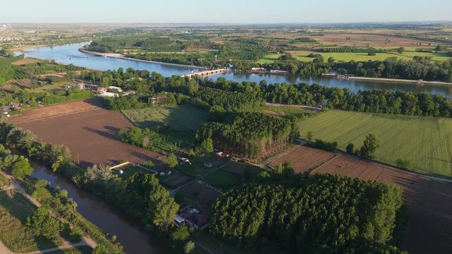 High wide aerial perspective over lush green agricultural plains and riverbank meadows outside Edirne, Turkey. Countryside landscape showing cultivated farmlands from a drone