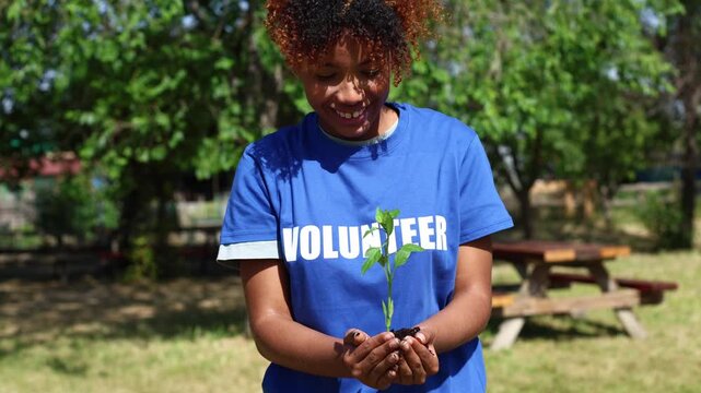 Volunteer holding green sapling for reforestation