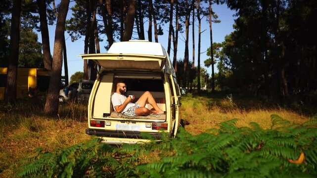 Man Relaxing in Open Vintage Campervan in Pine Forest &ndash; Van Life Lifestyle