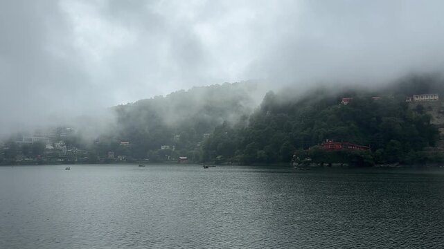 Nainital Lake Misty Foggy Mountain Landscape. Horizontal video of lake under low clouds and heavy fog rolling over green forested mountains. Ideal for India tourism travel ads.