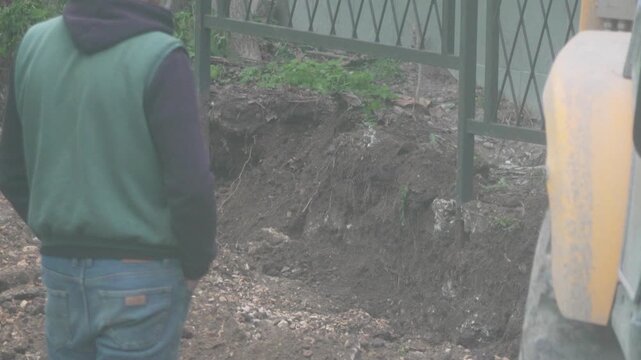 Heavy Machinery Excavation Worker Supervising Large Backhoe Digging Dirt Ground