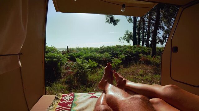 Cozy Van Life POV &ndash; Couple's Legs Resting in Open Campervan with Forest and Sea View