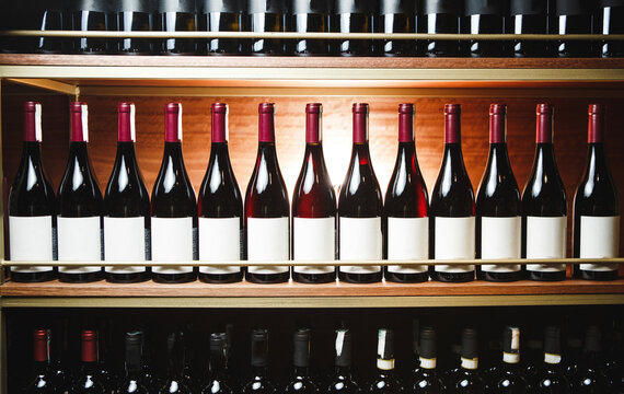Elite Wine Bottles Lined Up in Wooden Cellar Rack, Showcasing Collection