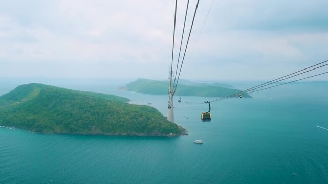 Cable car gondola gliding over lush green island hills and turquoise sea. Longest Hon Thom cable car ride in the world on Phu Quoc island, Vietnam. Modern tourism technology and infrastructure