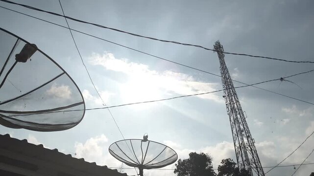 footage of satellite dish antennas and telecommunications towers with the evening sky in the background