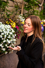 Fototapeta premium Woman Enjoying Vibrant Flowers in a Sunny Outdoor Setting While Embracing Nature's Beauty