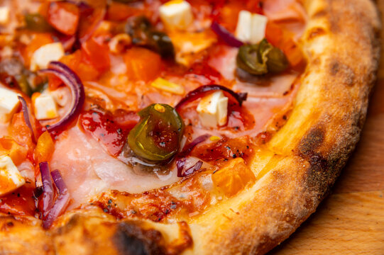 Close-up of freshly baked pizza with colorful toppings and crust