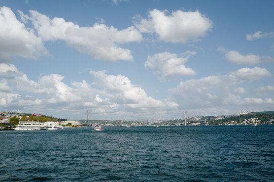Panoramic view of the majestic 15 Temmuz Şehitler K&ouml;pr&uuml;s&uuml; (Bosphorus Bridge) spanning the blue waters of Istanbul, connecting two continents under a clear sky.